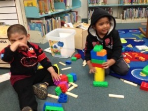Two younger participants in Abriendo Puertas play at the library in Half Moon Bay.