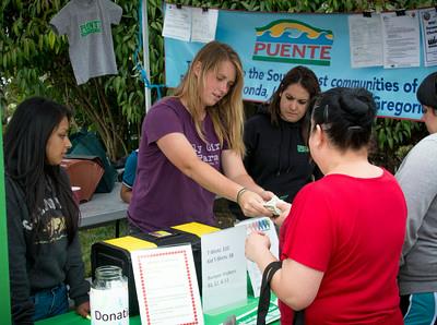 Charlea Binford assists a member of the community with receiving Pescadero Grown Tokens.